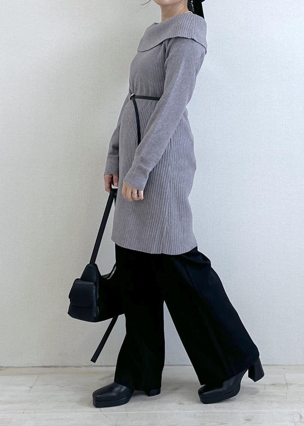 ブラック系のスラックス、ブラック系のショルダーバッグ、ブラック系のブーツを着用したレディースの秋コーディネートの3枚目の写真