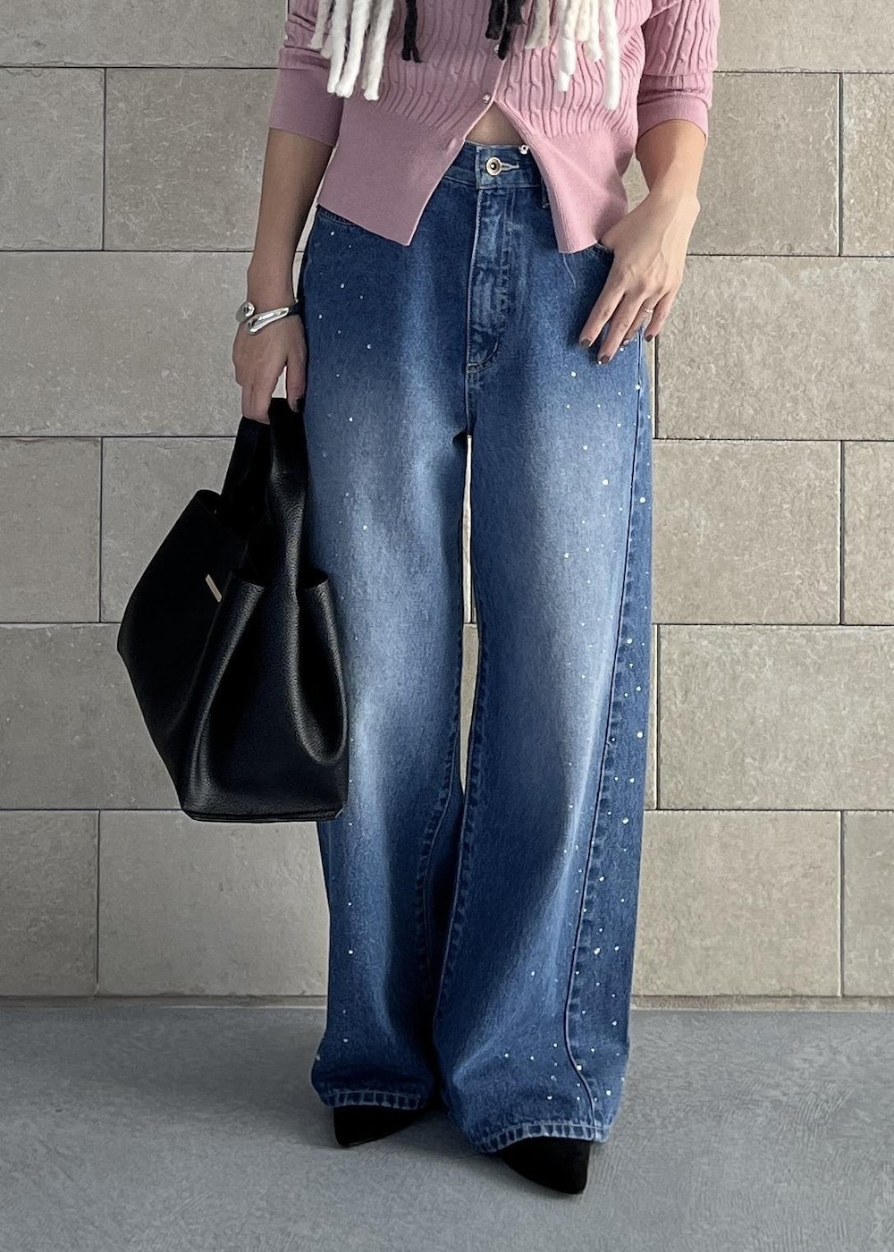 ブラック系のハンドバッグ、ピンク系のカーディガン/ボレロ、ブルー系のデニムパンツを着用したレディースの秋コーディネートの10枚目の写真