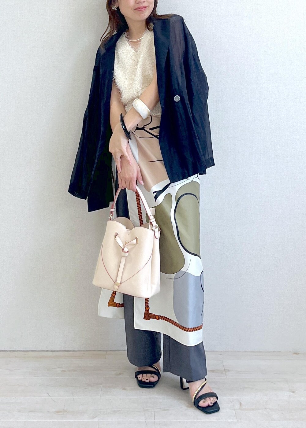 ベージュ系のショルダーバッグ、ブラック系のサンダル、ブラック系のテーラードジャケットを着用したレディースの夏コーディネートの8枚目の写真