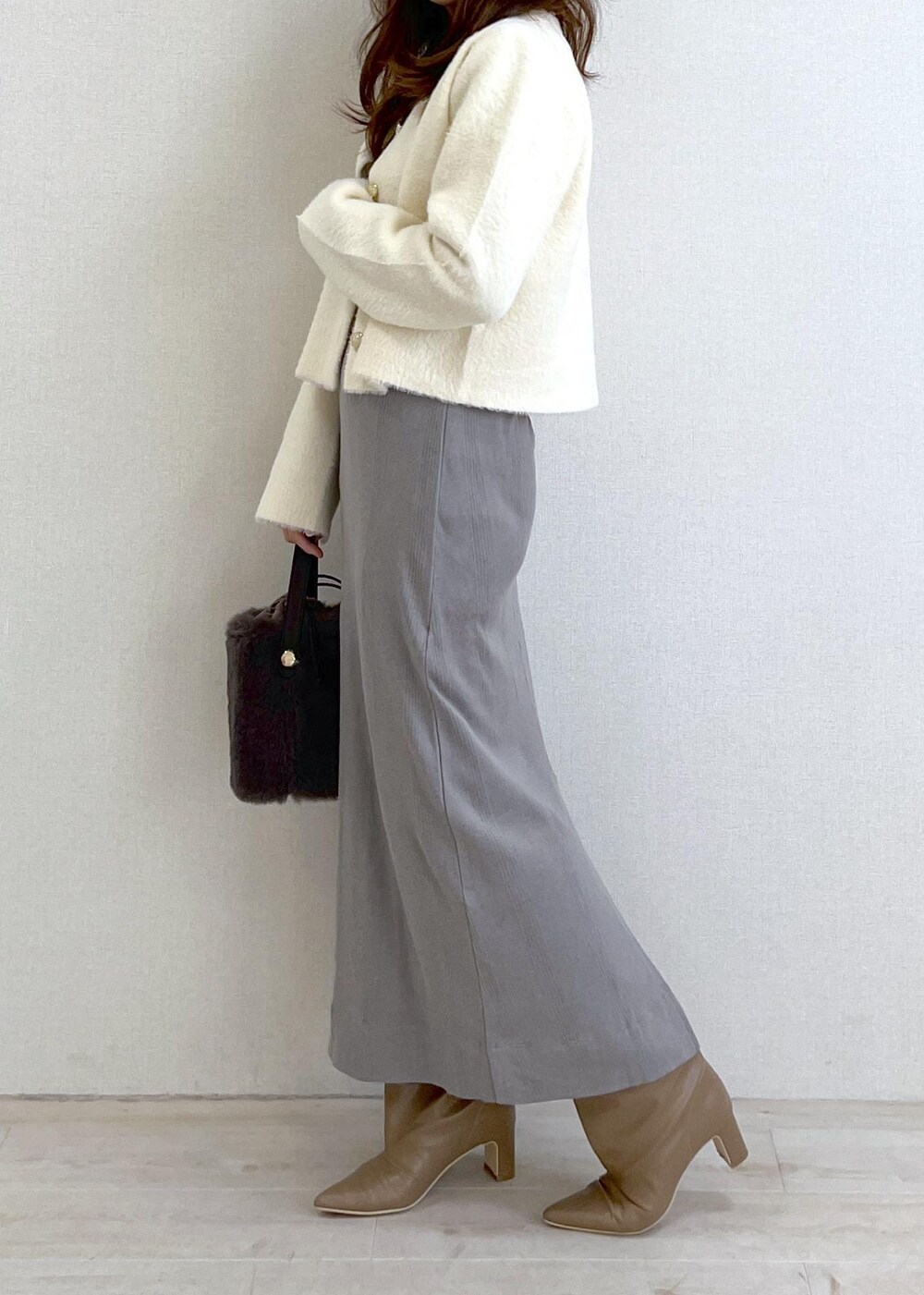 ベージュ系のブーツ、グレー系のショルダーバッグ、ホワイト系のカーディガン/ボレロを着用したレディースの冬コーディネートの2枚目の写真