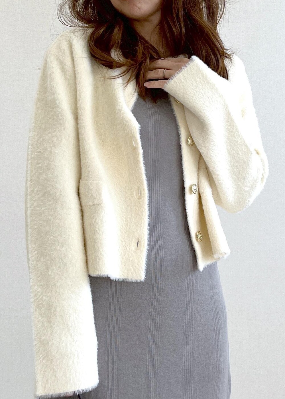 ベージュ系のブーツ、グレー系のショルダーバッグ、ホワイト系のカーディガン/ボレロを着用したレディースの冬コーディネートの5枚目の写真