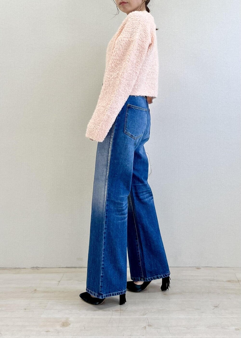 ピンク系のカーディガン/ボレロ、ブルー系のデニムパンツ、ホワイト系のボストンバッグを着用したレディースの冬コーディネートの2枚目の写真