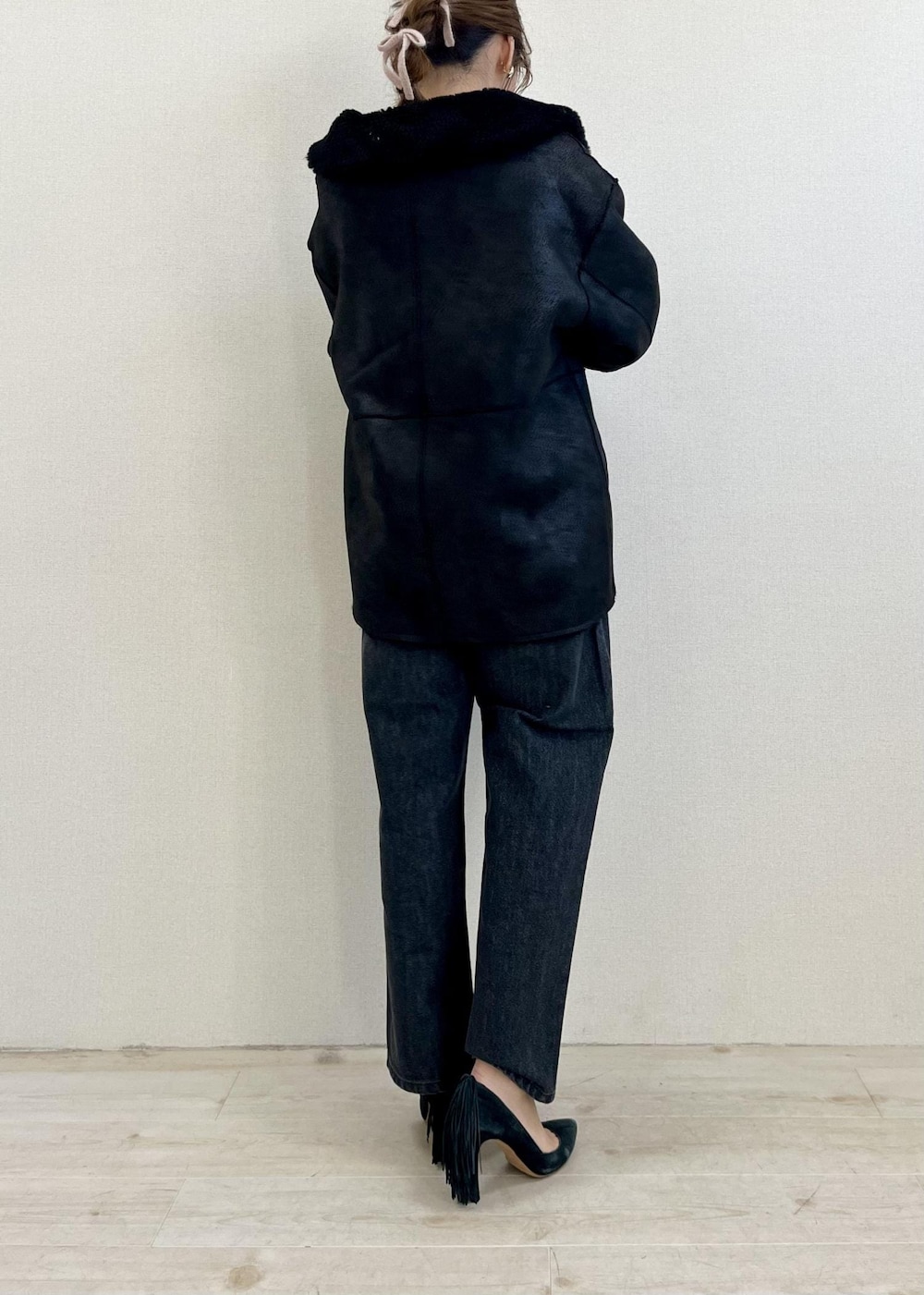 ブラック系のデニムパンツ、レッド系のニット/セーター、ブラック系のショルダーバッグを着用したレディースの冬コーディネートの2枚目の写真