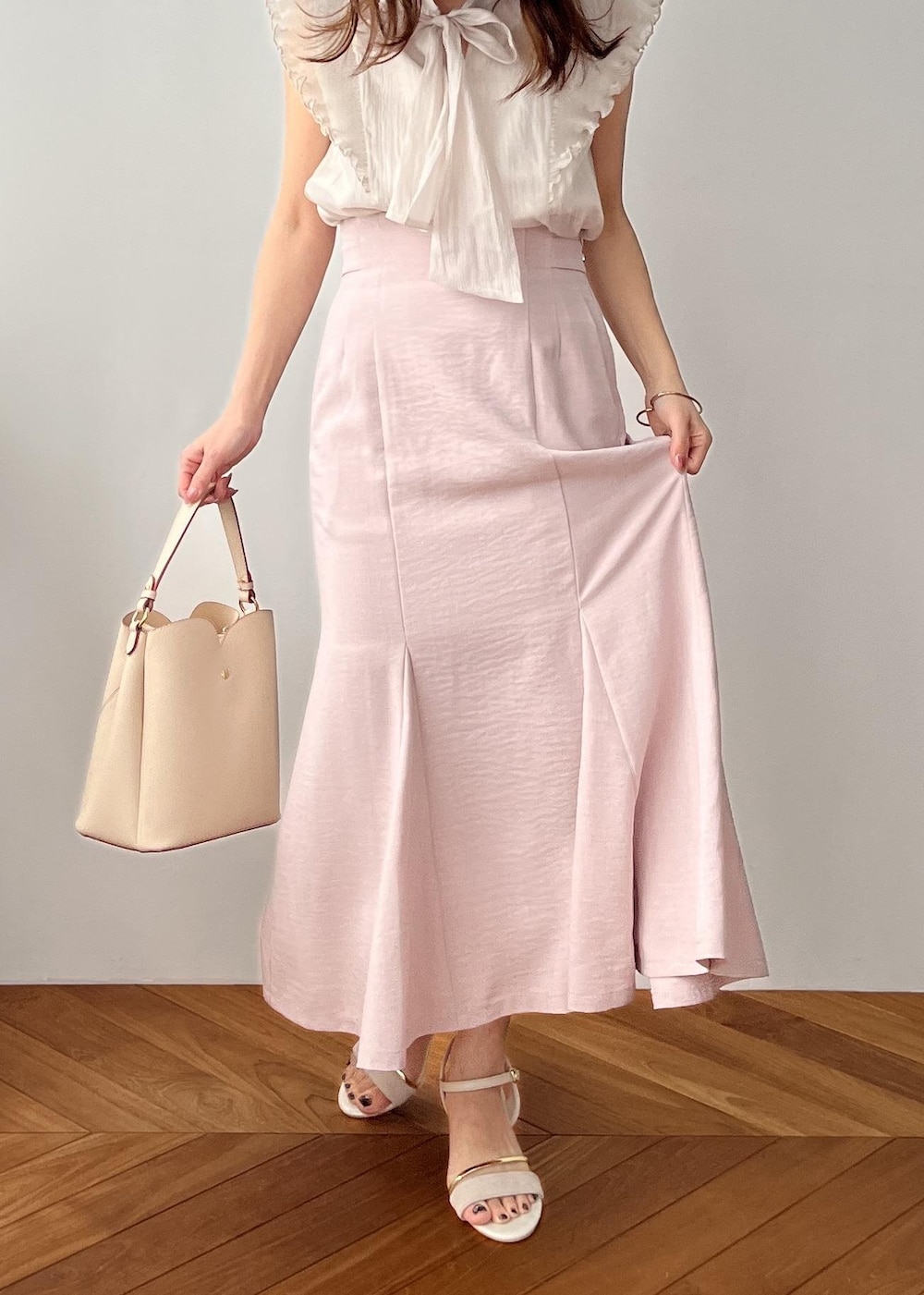 ベージュ系のショルダーバッグ、ピンク系のスカート、ホワイト系のサンダルを着用したレディースの春コーディネートの7枚目の写真