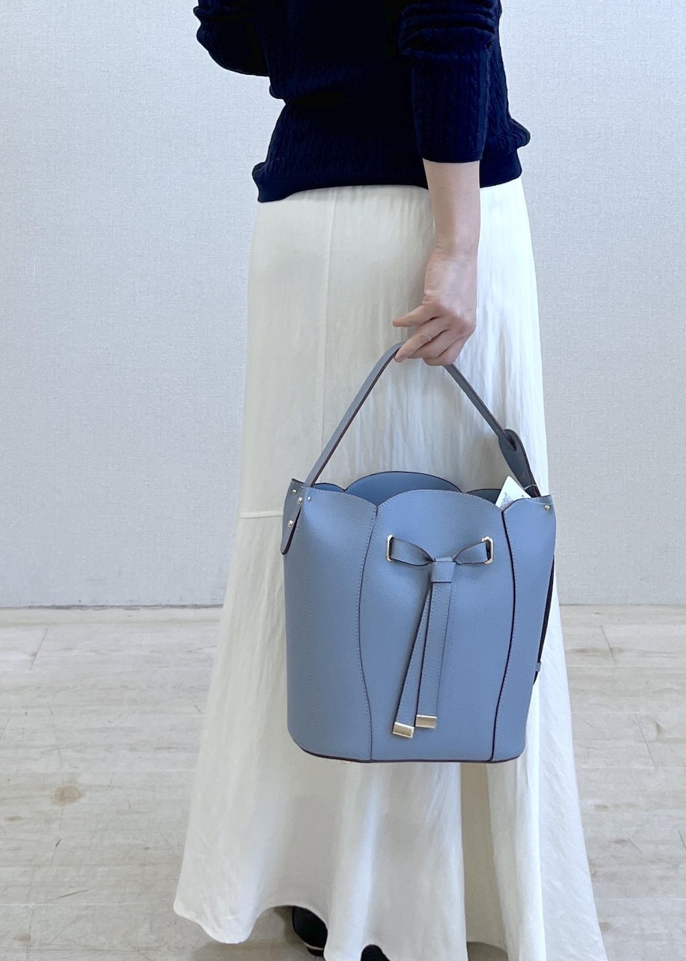 ブラック系のパンプス、ブルー系のショルダーバッグ、ベージュ系のトレンチコートを着用したレディースの春コーディネートの5枚目の写真