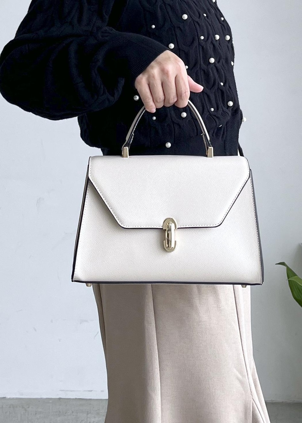 ブラック系のブーツ、ベージュ系のスカート、ブラック系のカーディガン/ボレロを着用したレディースの秋コーディネートの6枚目の写真