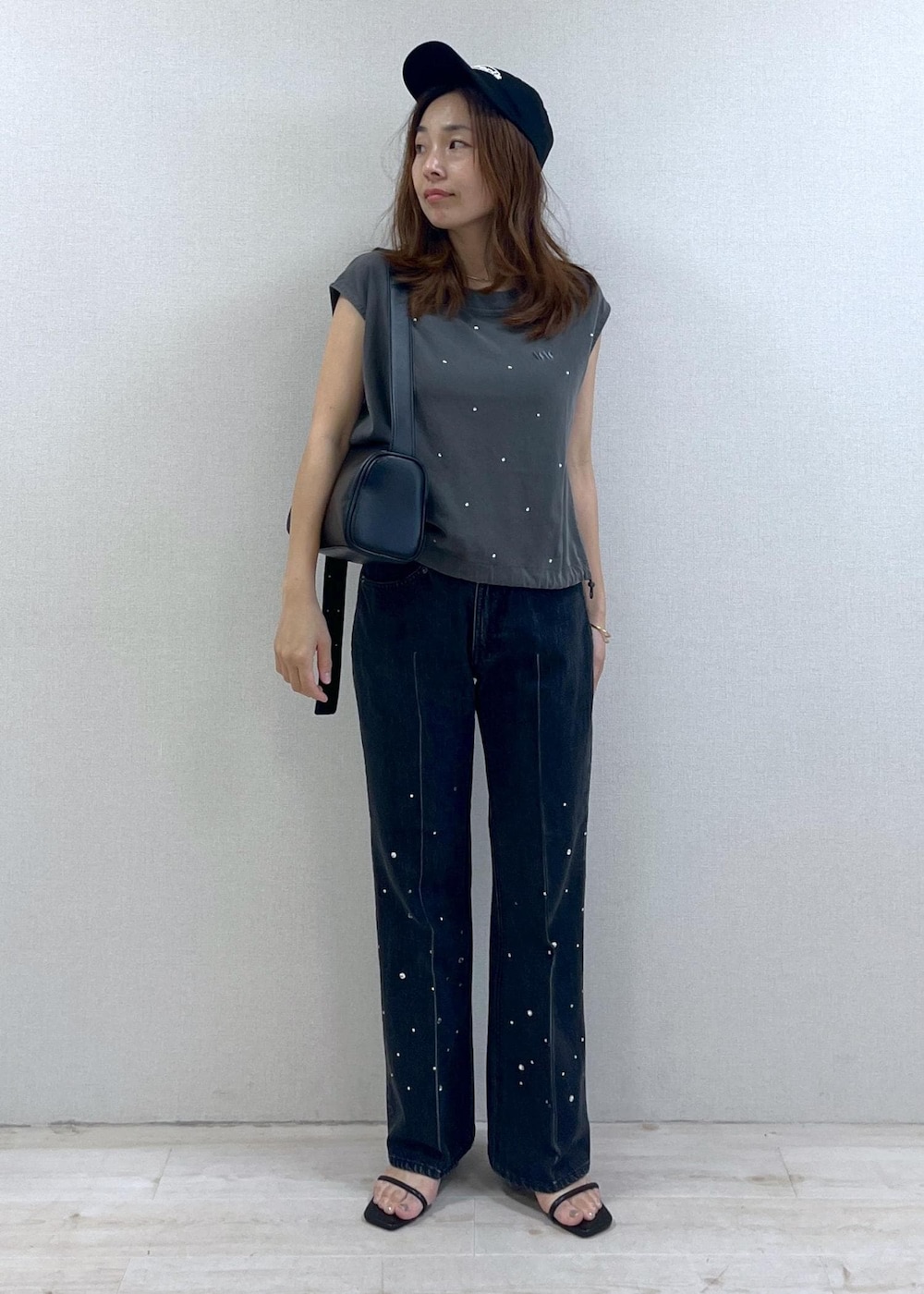 ブラック系のショルダーバッグ、ブラック系のサンダル、ブラック系のデニムパンツを着用したレディースの夏コーディネートの6枚目の写真