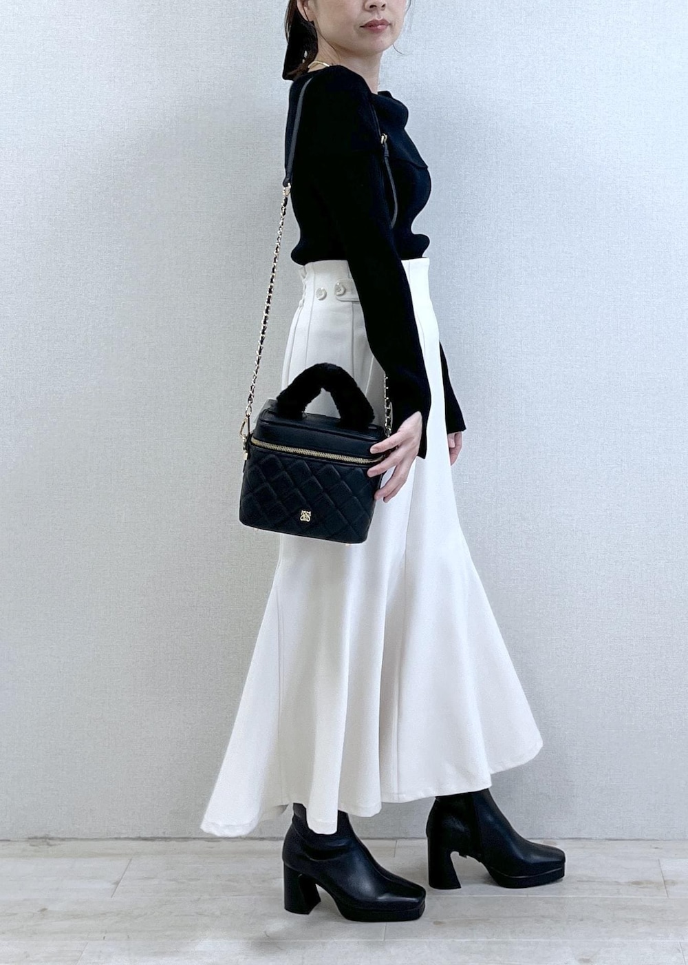 ブラック系のニット/セーター、ブラック系のダウンジャケット/コート、ブラック系のブーツを着用したレディースの冬コーディネートの3枚目の写真