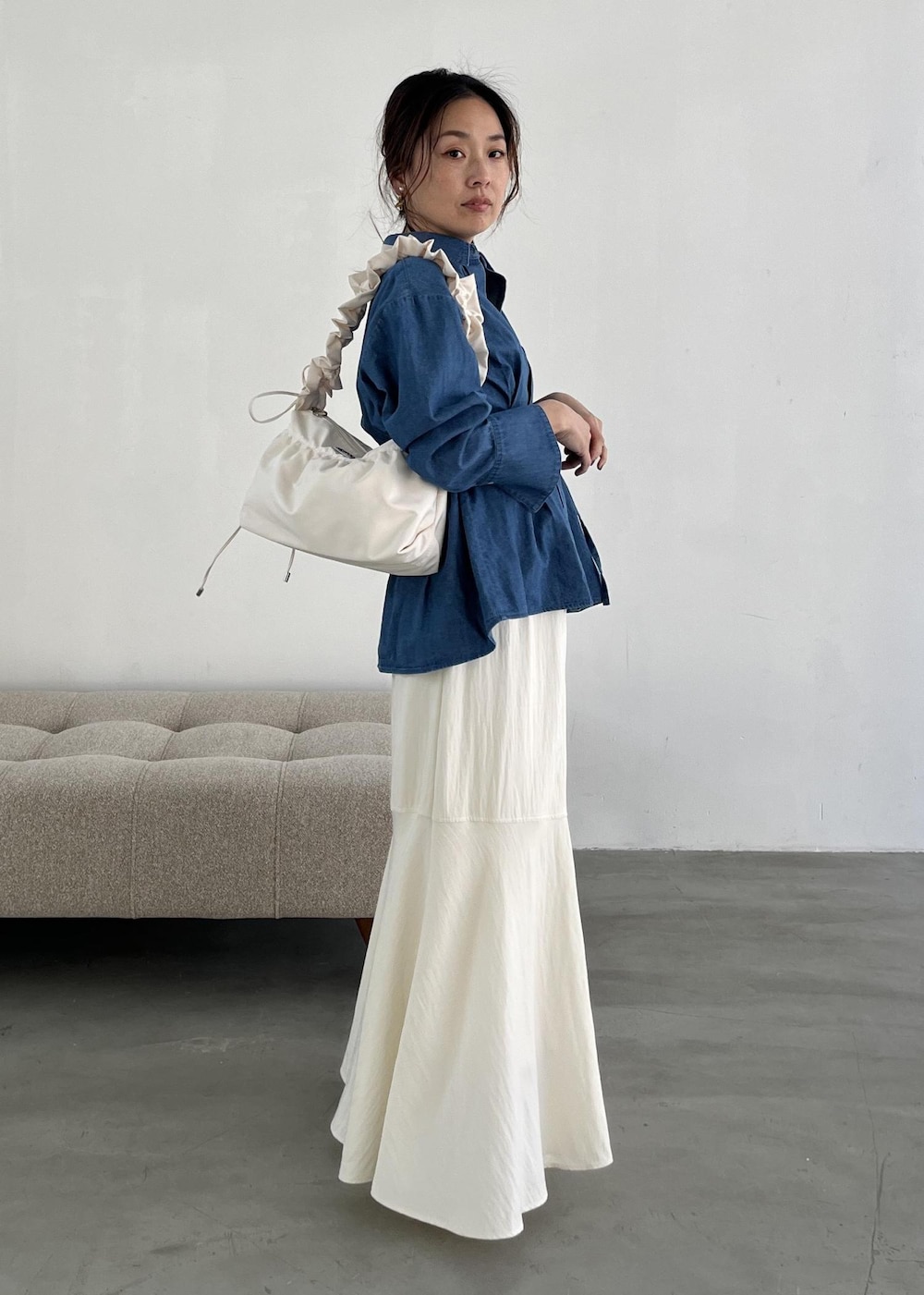 ホワイト系のショルダーバッグ、ホワイト系のパンプス、ホワイト系のスカートを着用したレディースの冬コーディネートの10枚目の写真