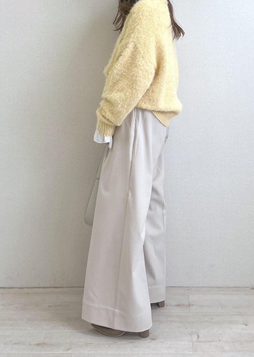 ベージュ系のブーツ、ホワイト系のハンドバッグ、ホワイト系のシャツ/ブラウスを着用したレディースの秋コーディネートの2枚目の写真