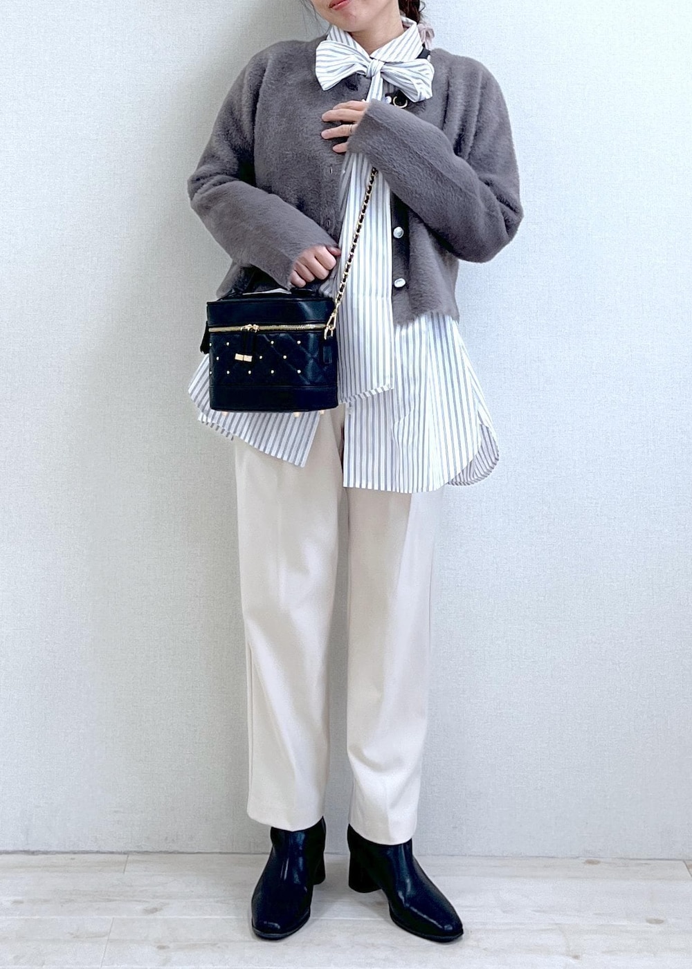 ブラック系のブーツ、ホワイト系のシャツ/ブラウス、ブラウン系のカーディガン/ボレロを着用したレディースの冬コーディネートの6枚目の写真