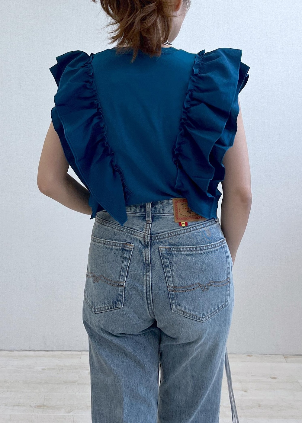 ベージュ系のドレスシューズ、ブルー系のTシャツ/カットソー、ブルー系のデニムパンツを着用したレディースの夏コーディネートの6枚目の写真