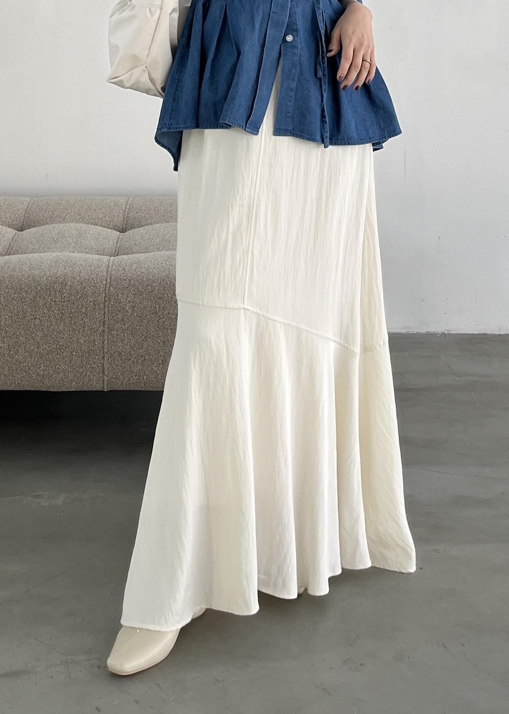 ホワイト系のショルダーバッグ、ホワイト系のパンプス、ホワイト系のスカートを着用したレディースの冬コーディネートの7枚目の写真