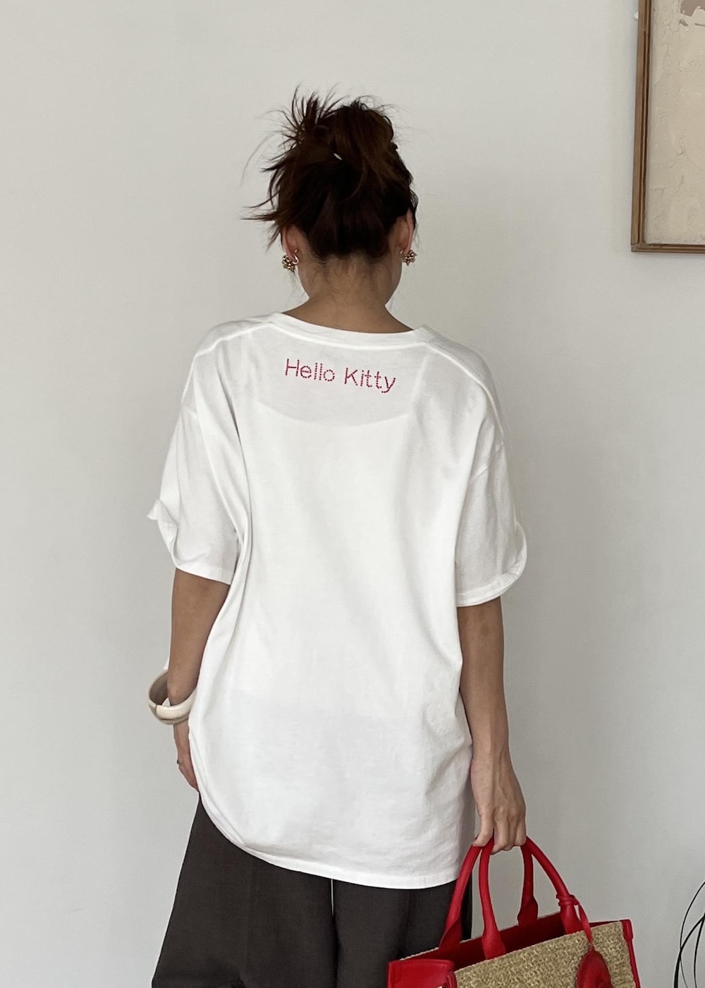 レッド系のトートバッグ、ホワイト系のTシャツ/カットソーを着用したレディースの夏コーディネートの8枚目の写真