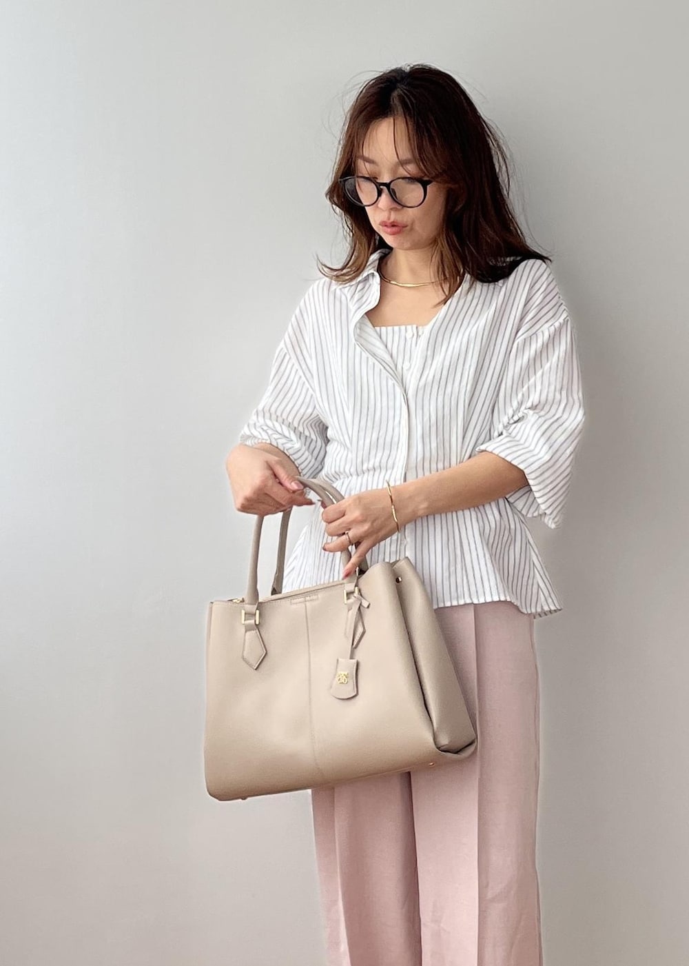 ピンク系のその他パンツ、ベージュ系のトートバッグ、ホワイト系のシャツ/ブラウスを着用したレディースの春コーディネートの10枚目の写真