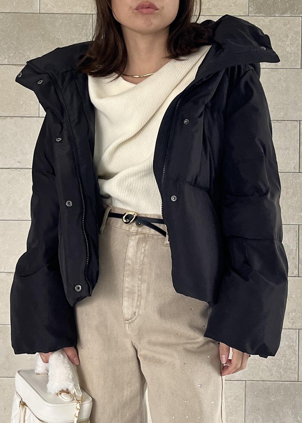 ブラック系のダウンジャケット/コート、ベージュ系のブーツ、ホワイト系のハンドバッグを着用したレディースの秋コーディネートの8枚目の写真