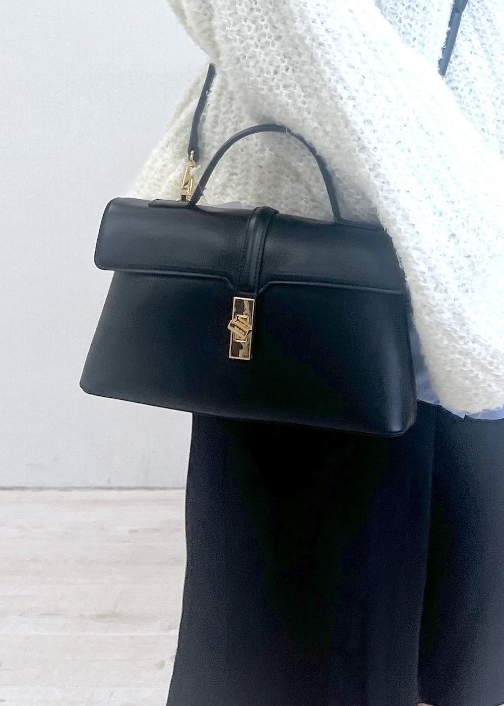 ブラック系のショルダーバッグ、ブラック系のブーツ、ブラック系のその他パンツを着用したレディースの秋コーディネートの5枚目の写真