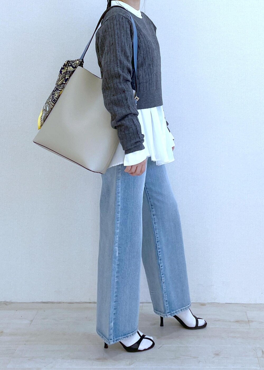 ベージュ系のショルダーバッグ、ホワイト系のシャツ/ブラウス、ブルー系のデニムパンツを着用したレディースの冬コーディネートの3枚目の写真