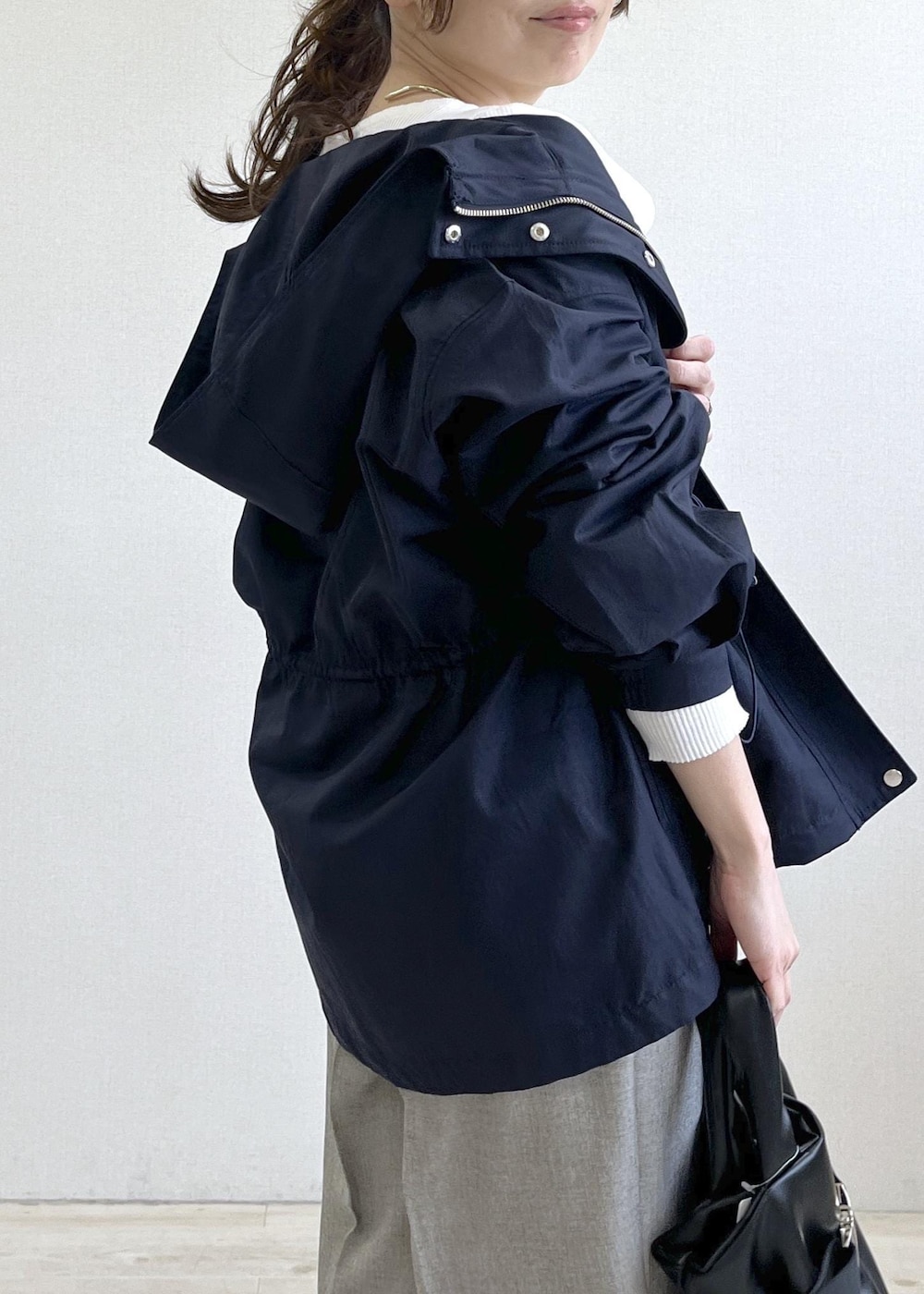 ブラック系のトートバッグ、ブルー系のナイロンジャケット、グレー系のその他パンツを着用したレディースの春コーディネートの6枚目の写真