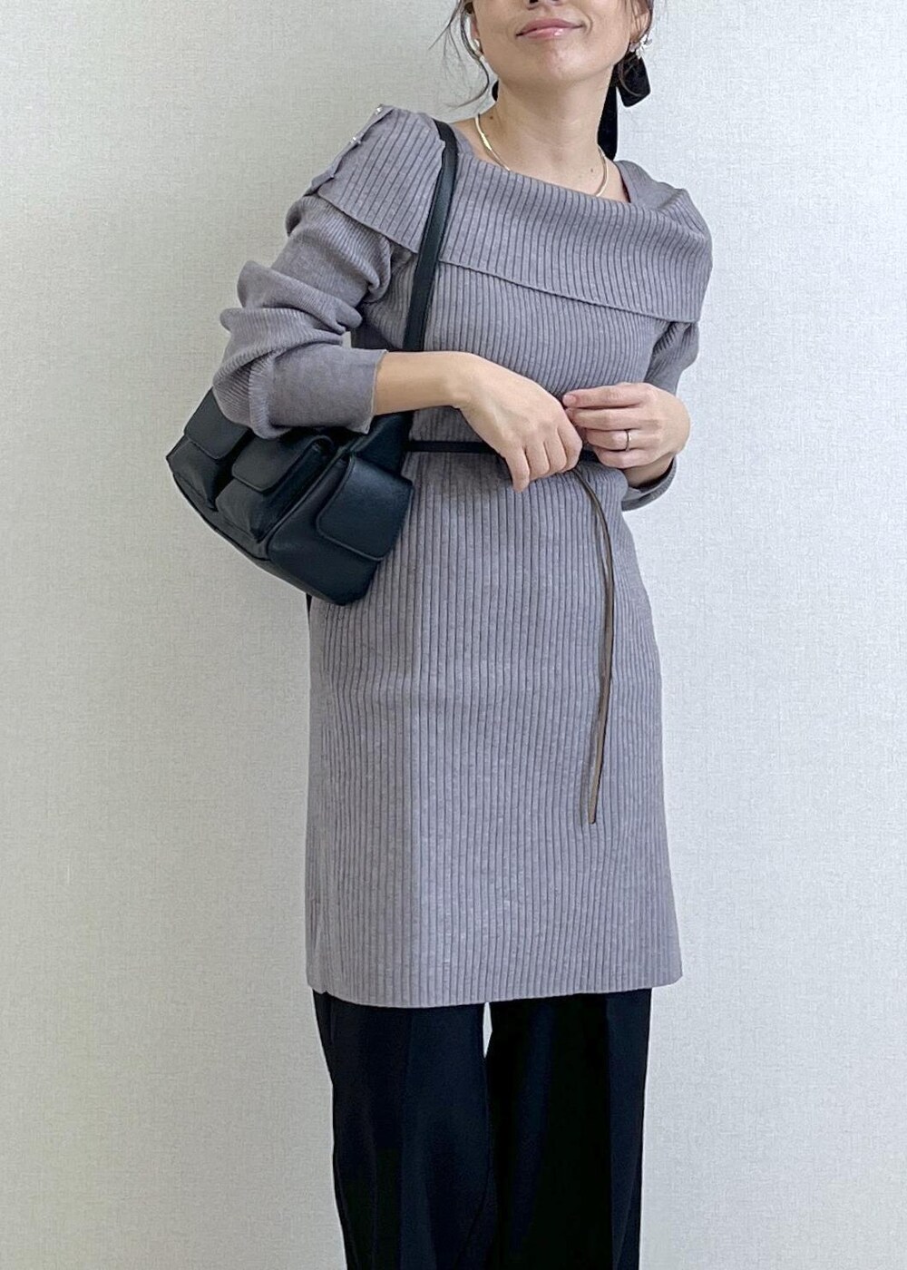 ブラック系のスラックス、ブラック系のショルダーバッグ、ブラック系のブーツを着用したレディースの秋コーディネートの2枚目の写真