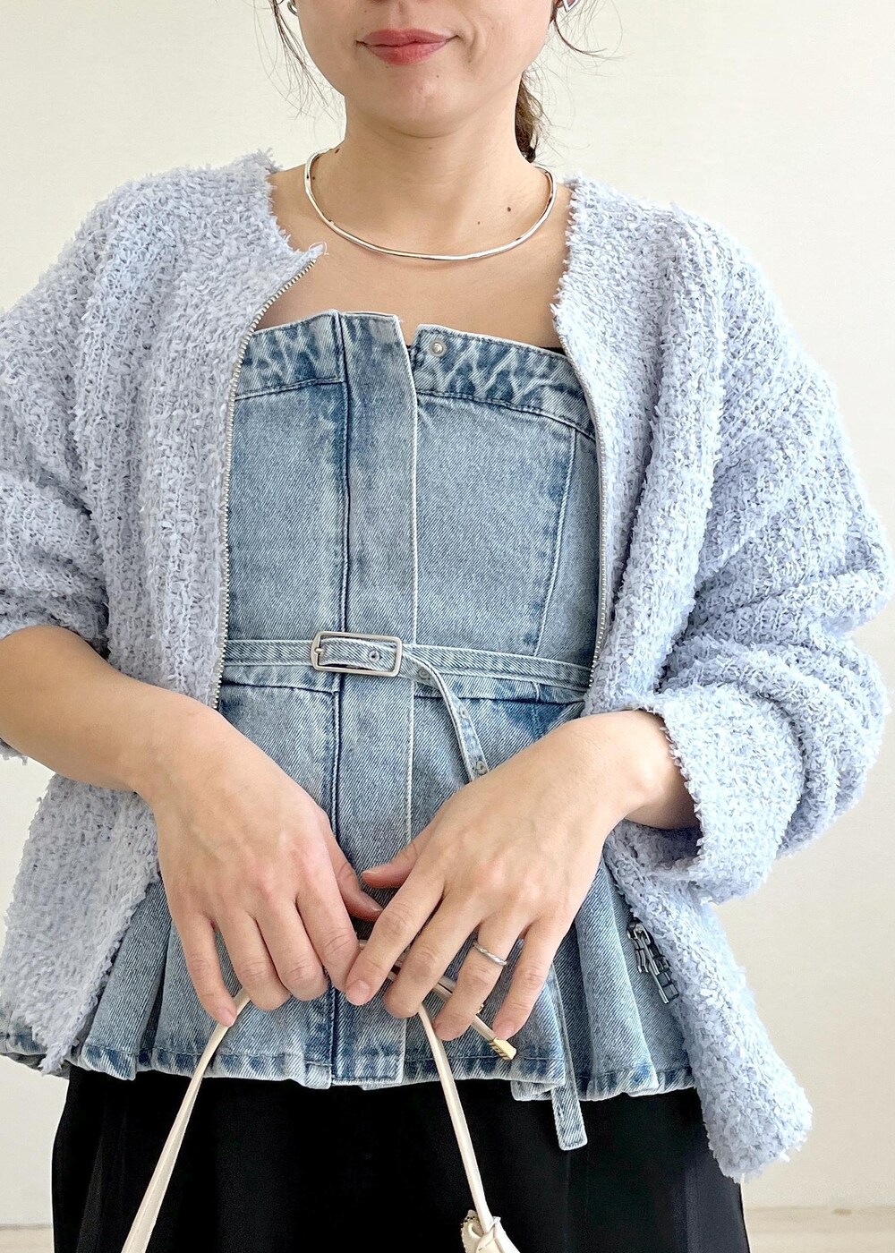 ホワイト系のハンドバッグ、ブルー系のカーディガン/ボレロ、ブラック系のサロペット/オーバーオールを着用したレディースの春コーディネートの5枚目の写真