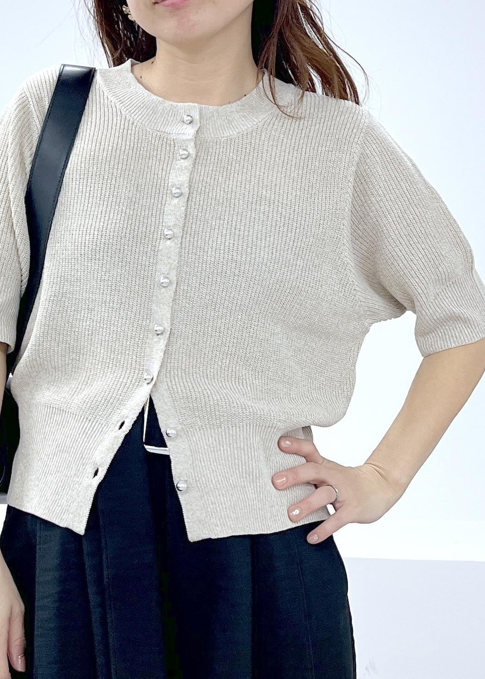 ブラック系のその他パンツ、ブラック系のショルダーバッグ、ホワイト系のカーディガン/ボレロを着用したレディースの春コーディネートの5枚目の写真
