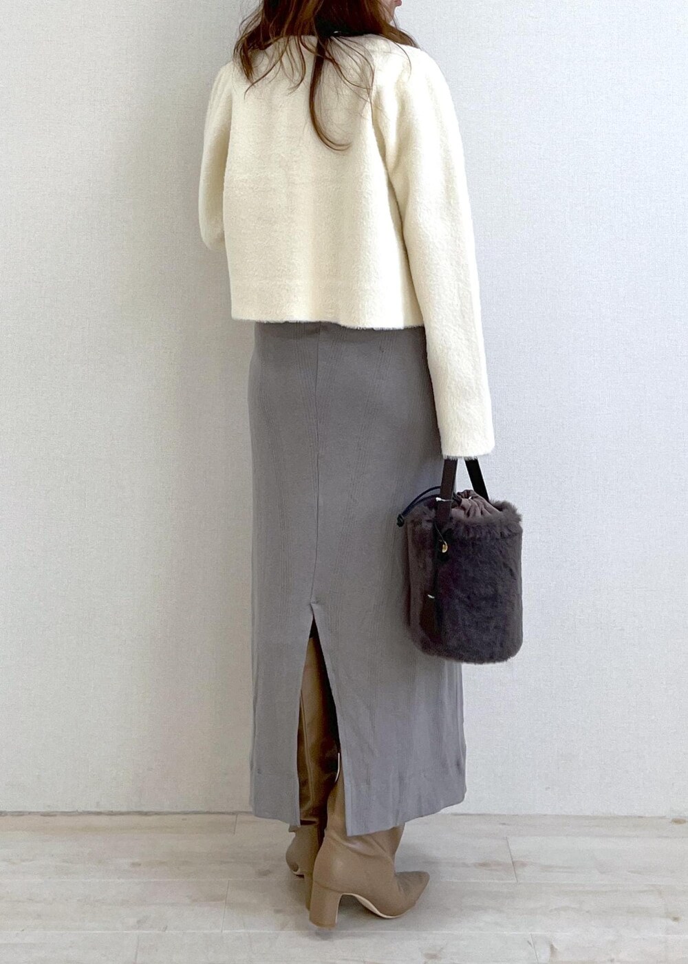 ベージュ系のブーツ、グレー系のショルダーバッグ、ホワイト系のカーディガン/ボレロを着用したレディースの冬コーディネートの4枚目の写真