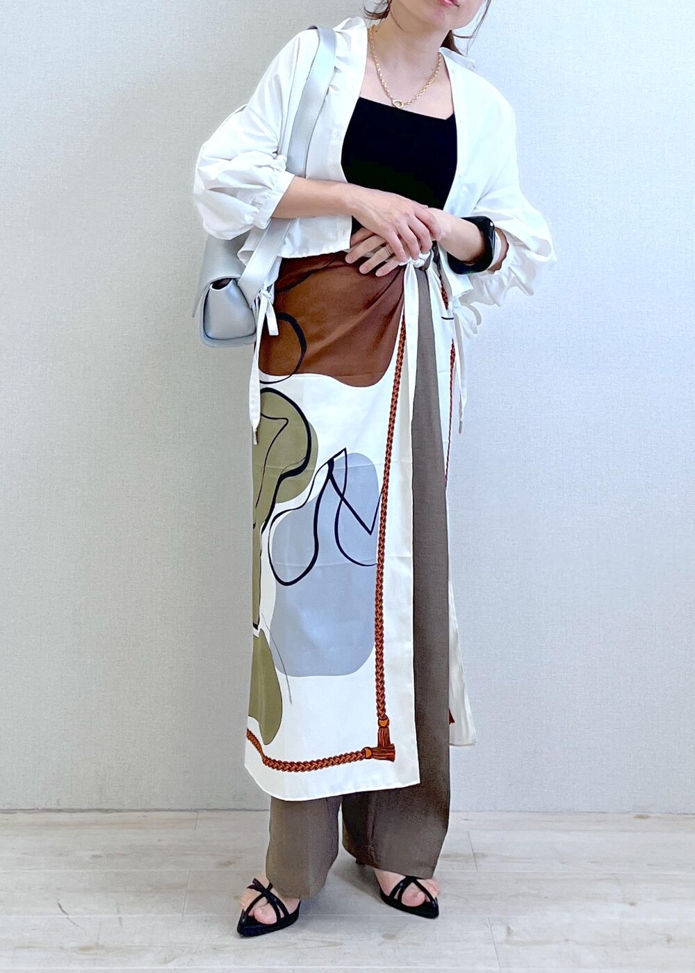 ブラック系のキャミソール、シルバー系のショルダーバッグ、ブラック系のサンダルを着用したレディースの春コーディネートの7枚目の写真