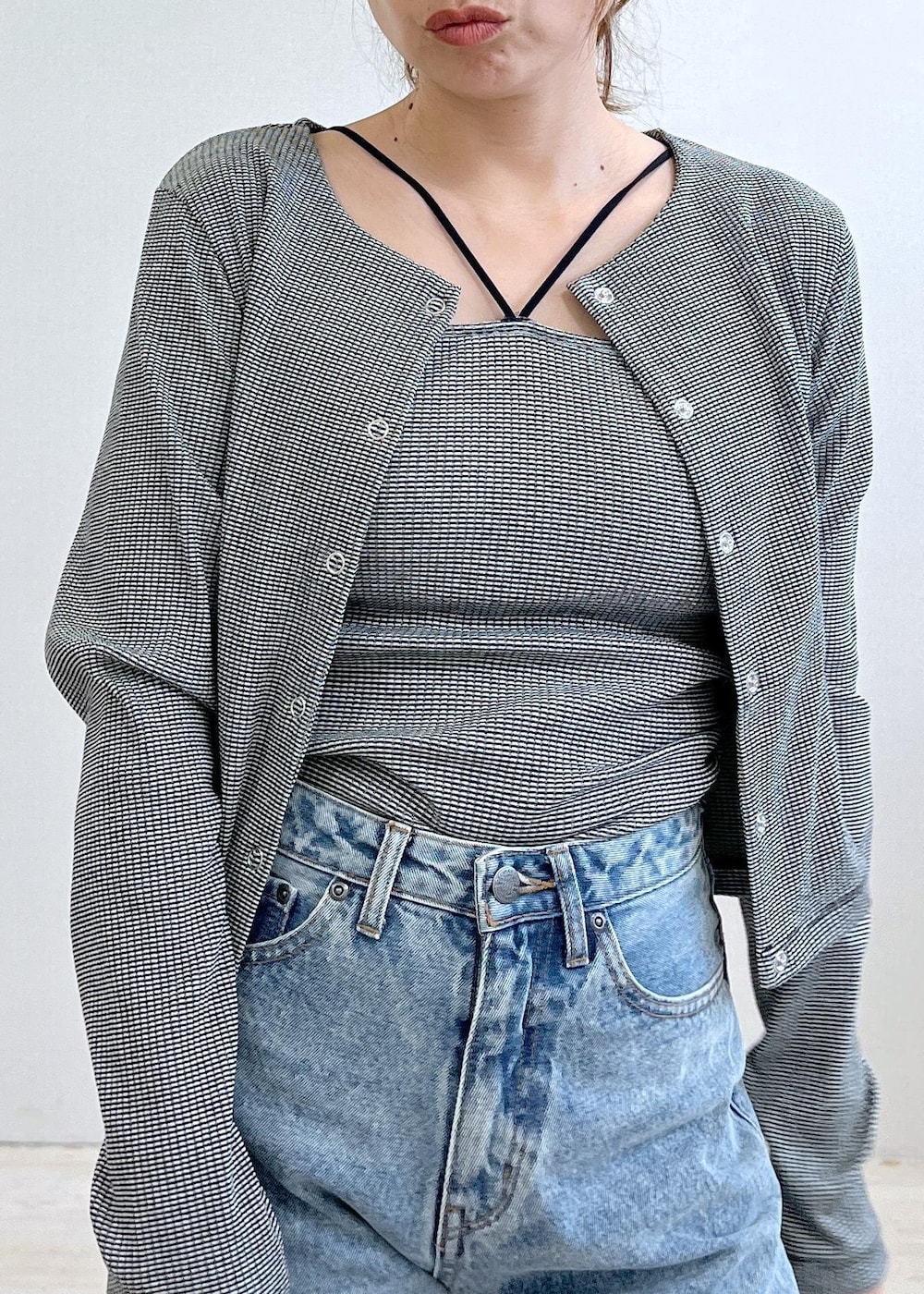 ベージュ系のドレスシューズ、ブラック系のアンサンブル、ブルー系のデニムパンツを着用したレディースの秋コーディネートの4枚目の写真