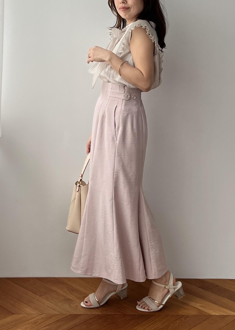 ベージュ系のショルダーバッグ、ピンク系のスカート、ホワイト系のサンダルを着用したレディースの春コーディネートの9枚目の写真