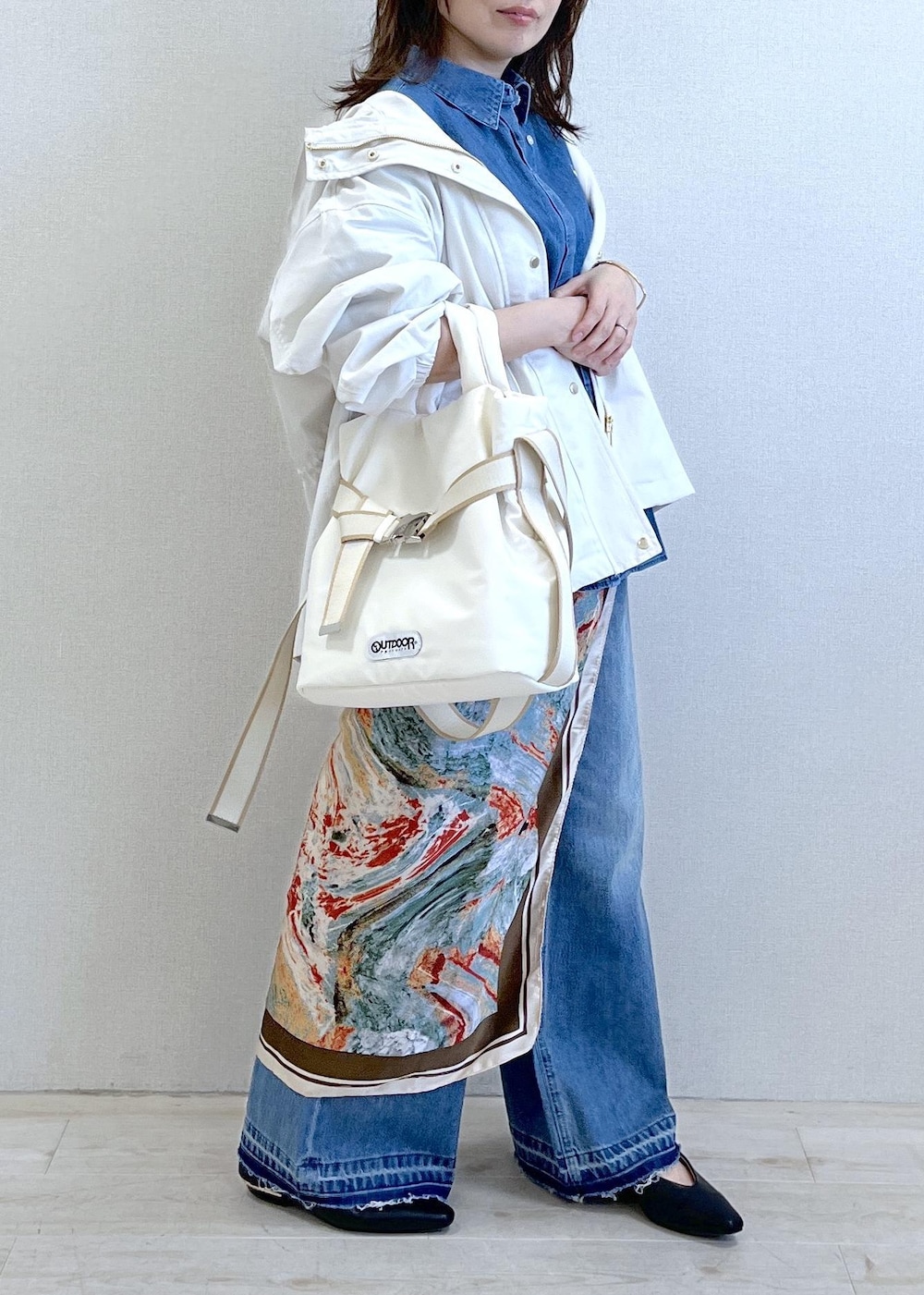 ブラック系のパンプス、ホワイト系のトートバッグ、ホワイト系のナイロンジャケットを着用したレディースの春コーディネートの8枚目の写真