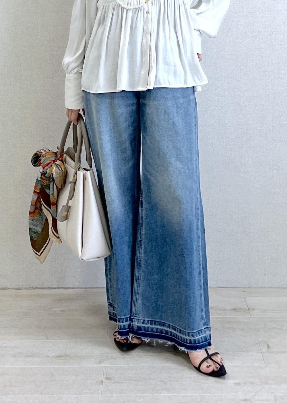 ブラック系のキャミソール、ブルー系のデニムパンツ、ブラック系のカーディガン/ボレロを着用したレディースの春コーディネートの7枚目の写真