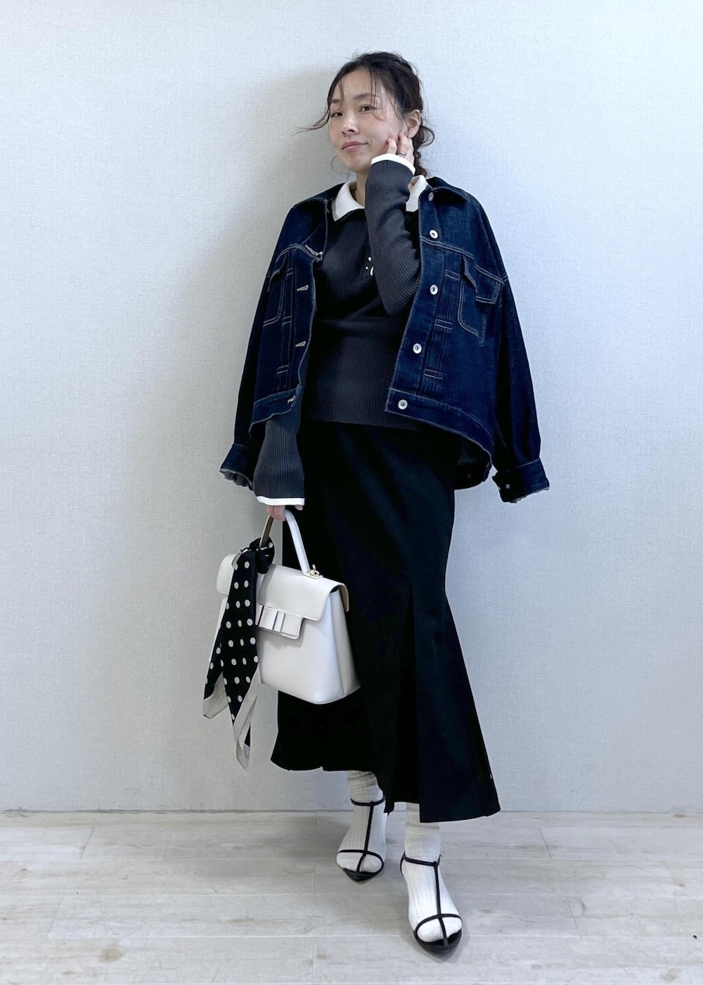 ブルー系のデニムジャケット、ブラック系のスカート、グレー系のニット/セーターを着用したレディースの冬コーディネートの10枚目の写真