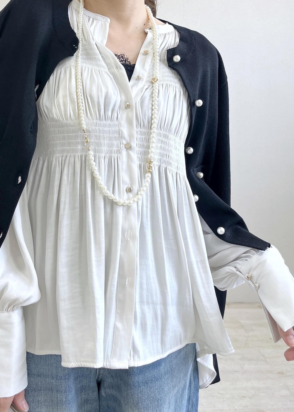 ブラック系のキャミソール、ブルー系のデニムパンツ、ブラック系のカーディガン/ボレロを着用したレディースの春コーディネートの5枚目の写真