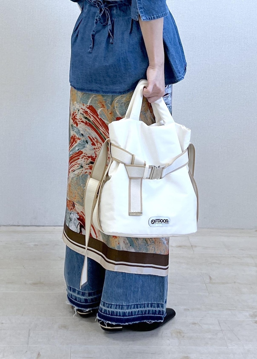 ブラック系のパンプス、ホワイト系のトートバッグ、ホワイト系のナイロンジャケットを着用したレディースの春コーディネートの5枚目の写真