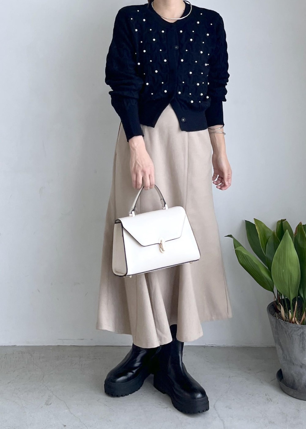 ブラック系のブーツ、ベージュ系のスカート、ブラック系のカーディガン/ボレロを着用したレディースの秋コーディネートの8枚目の写真