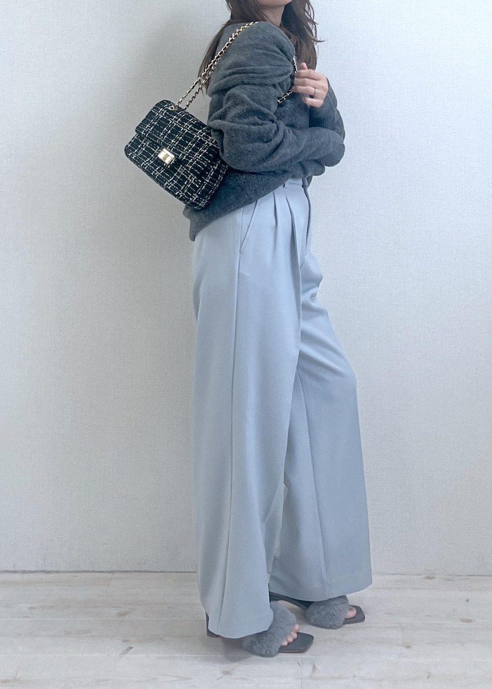 グレー系のドレスシューズ、ブラック系のショルダーバッグ、グレー系のニット/セーターを着用したレディースの秋コーディネートの2枚目の写真