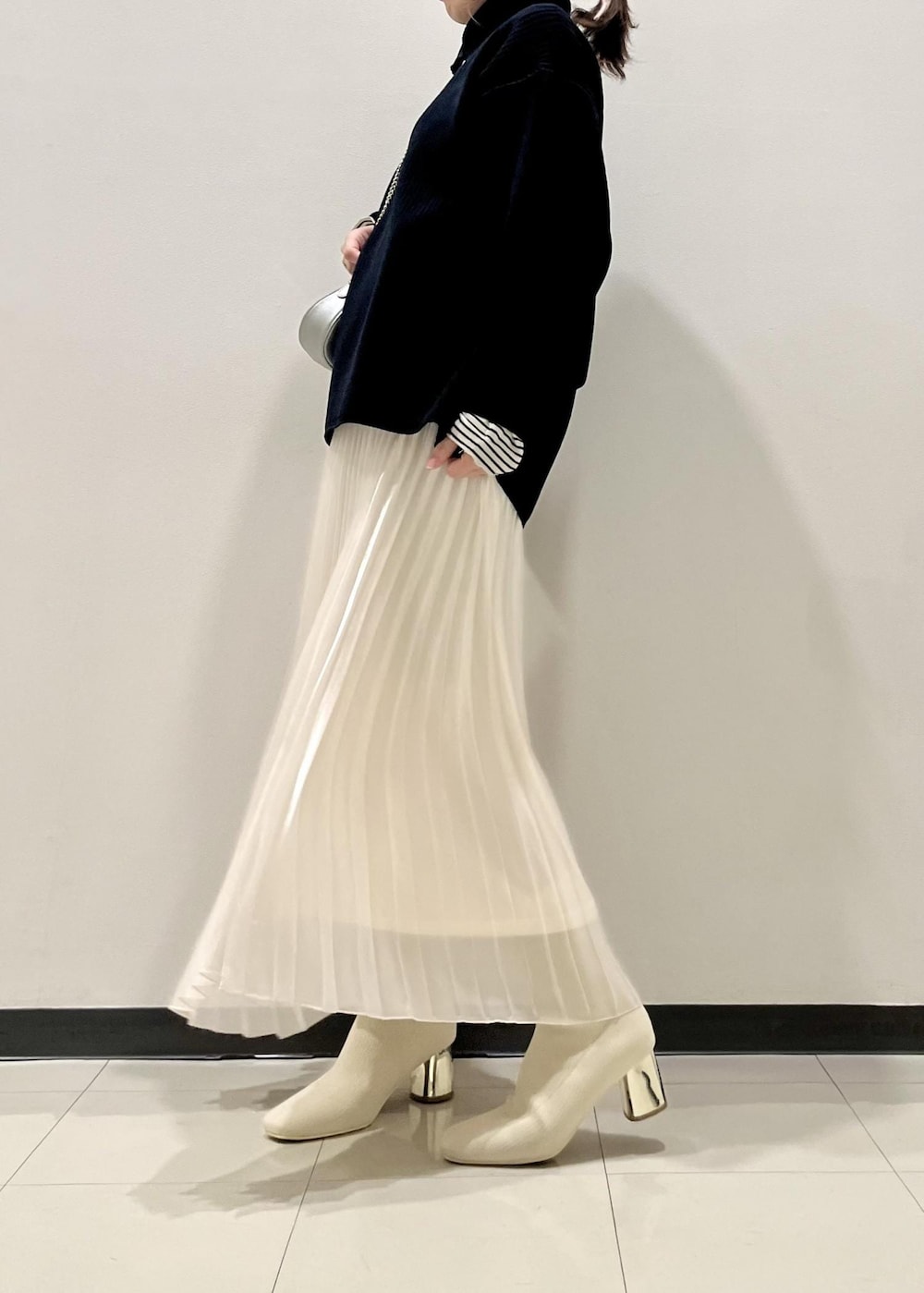 ホワイト系のブーツ、ホワイト系のニット/セーター、ブルー系のニット/セーターを着用したレディースの冬コーディネートの2枚目の写真