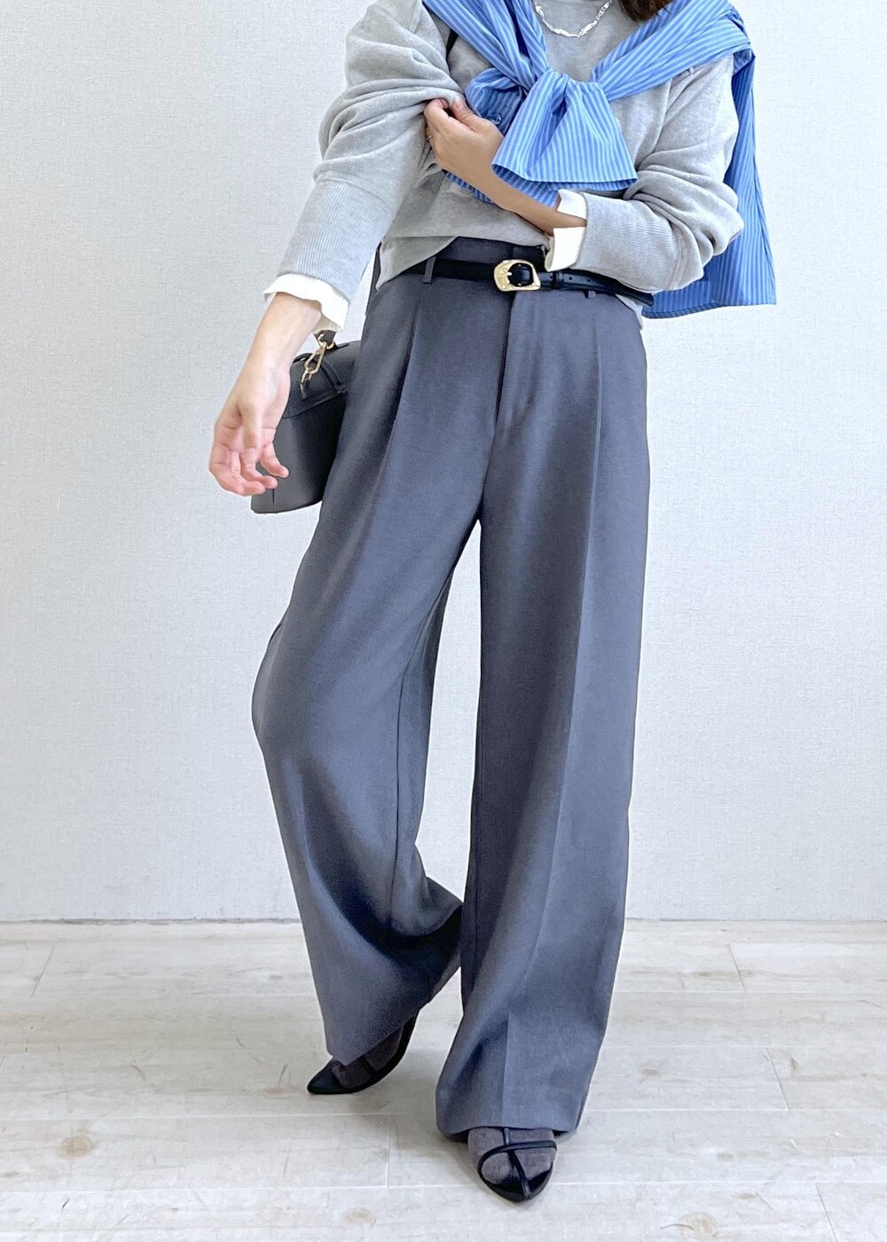 グレー系のショルダーバッグ、グレー系のスラックス、ブルー系のシャツ/ブラウスを着用したレディースの秋コーディネートの7枚目の写真