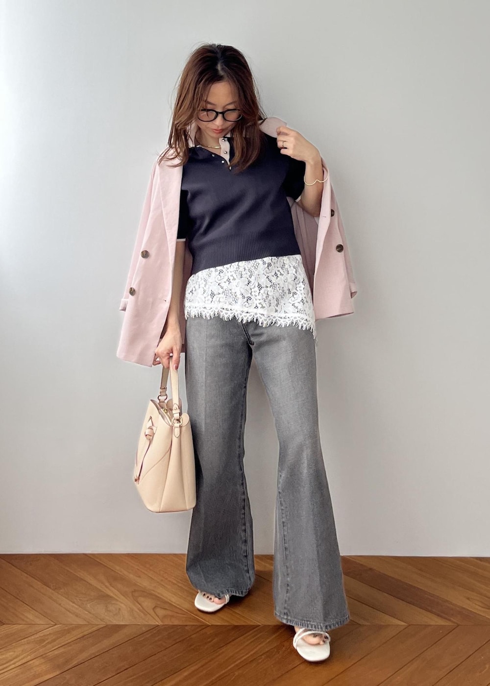 ベージュ系のショルダーバッグ、ピンク系のテーラードジャケット、グレー系のポロシャツを着用したレディースの春コーディネートの6枚目の写真