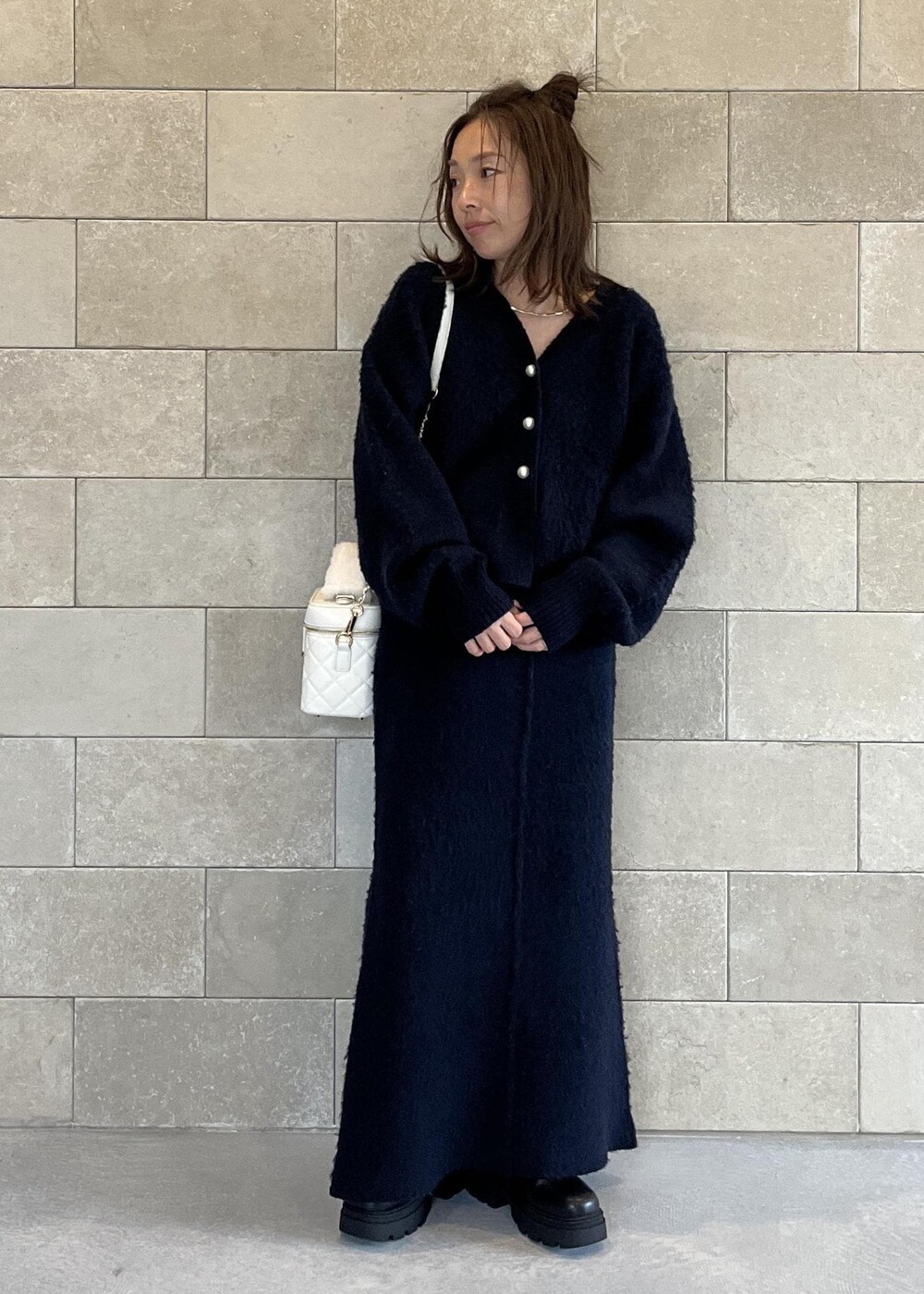 ブラック系のブーツ、ホワイト系のハンドバッグ、ブルー系のスカートを着用したレディースの秋コーディネートの8枚目の写真