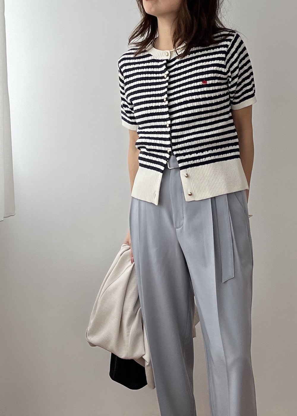 ブラック系のショルダーバッグ、ホワイト系のパンプス、ブルー系のその他パンツを着用したレディースの春コーディネートの5枚目の写真