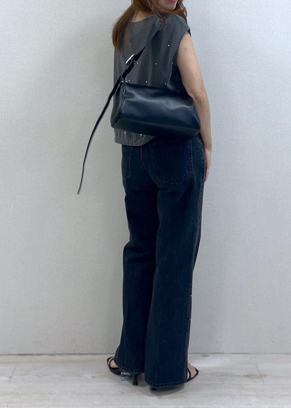 ブラック系のショルダーバッグ、ブラック系のサンダル、ブラック系のデニムパンツを着用したレディースの夏コーディネートの2枚目の写真