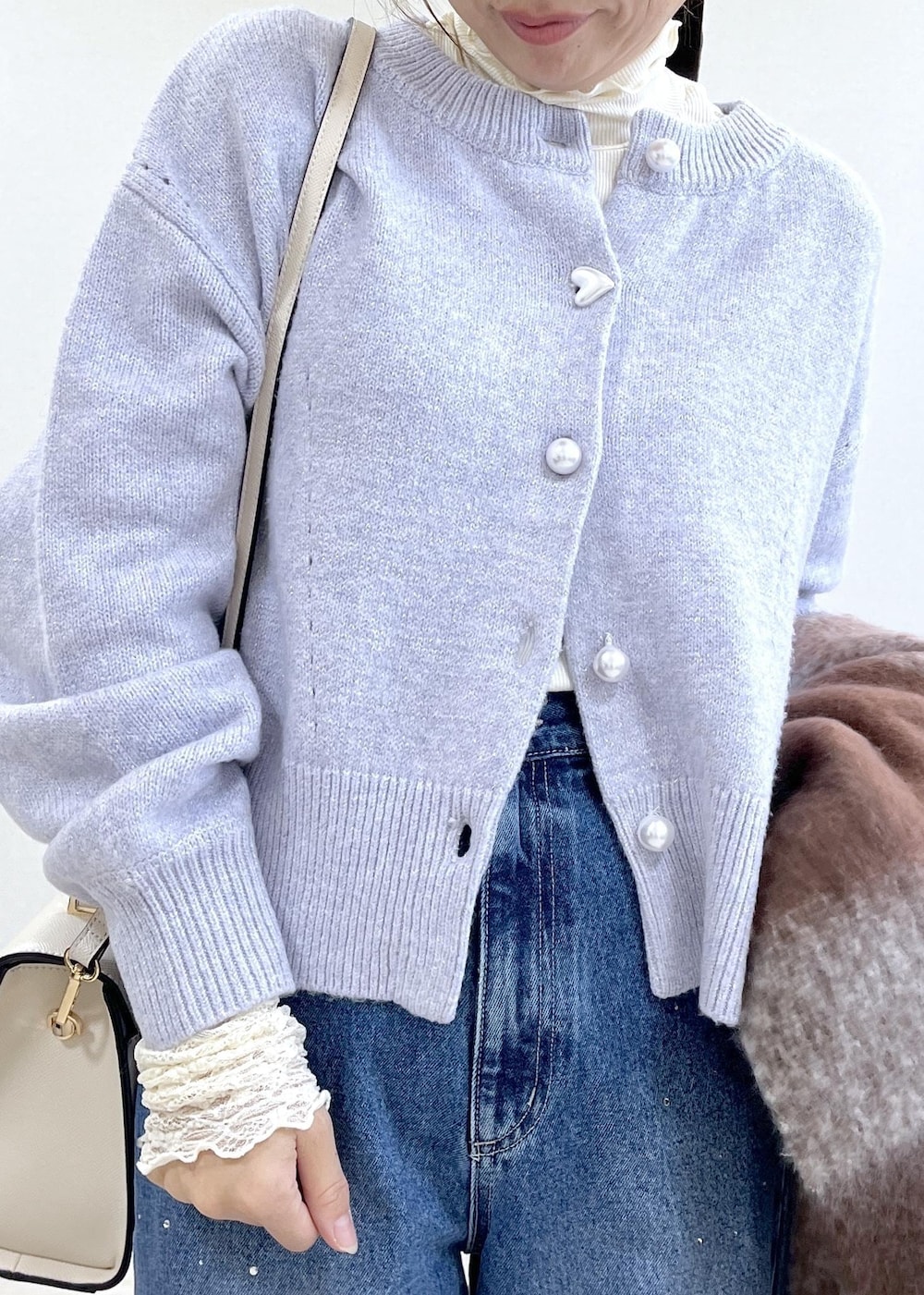 パープル系のカーディガン/ボレロ、ホワイト系のTシャツ/カットソー、ブラック系のブーツを着用したレディースの秋コーディネートの9枚目の写真