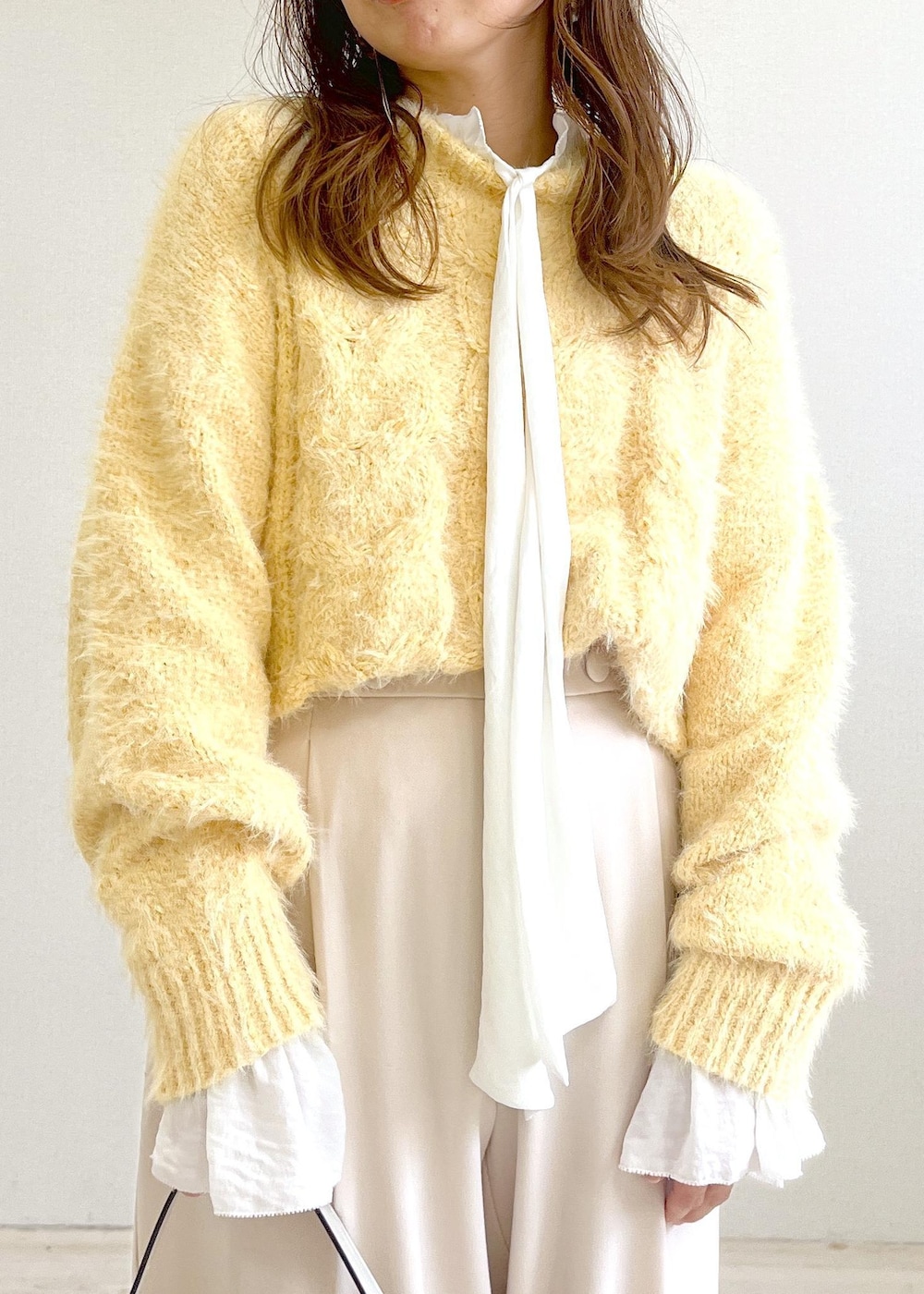 ベージュ系のブーツ、ホワイト系のハンドバッグ、ホワイト系のシャツ/ブラウスを着用したレディースの秋コーディネートの7枚目の写真