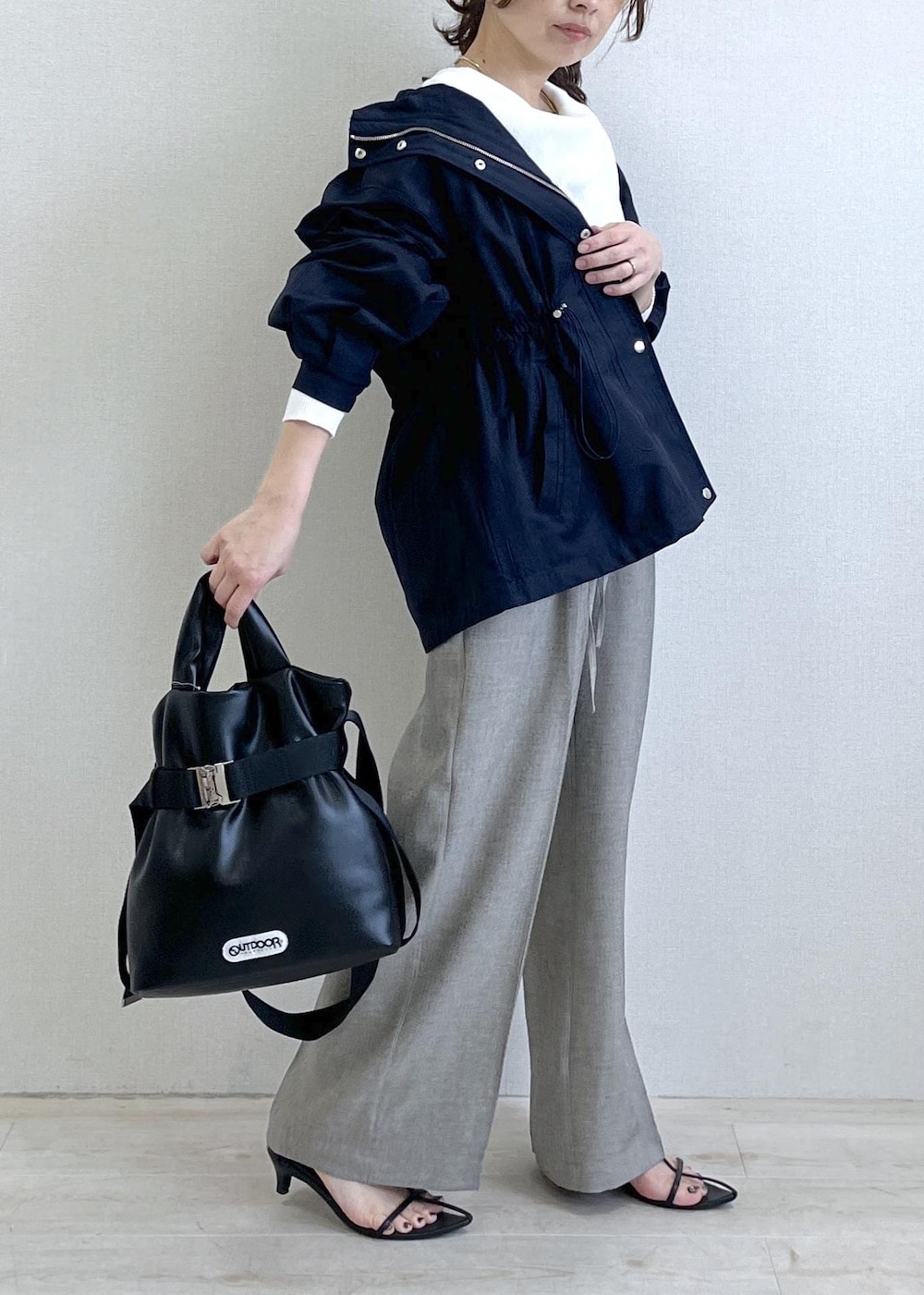ブラック系のトートバッグ、ブルー系のナイロンジャケット、グレー系のその他パンツを着用したレディースの春コーディネートの4枚目の写真