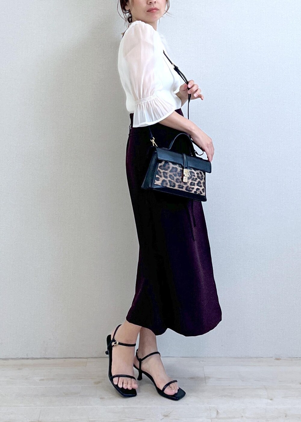 ブラック系のサンダル、ホワイト系のTシャツ/カットソー、ブラウン系のスカートを着用したレディースの夏コーディネートの6枚目の写真