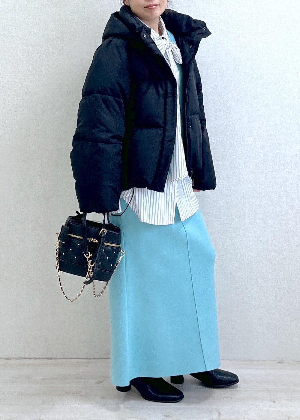 ブラック系のブーツ、ブルー系のスカート、ホワイト系のシャツ/ブラウスを着用したレディースの冬コーディネートの3枚目の写真