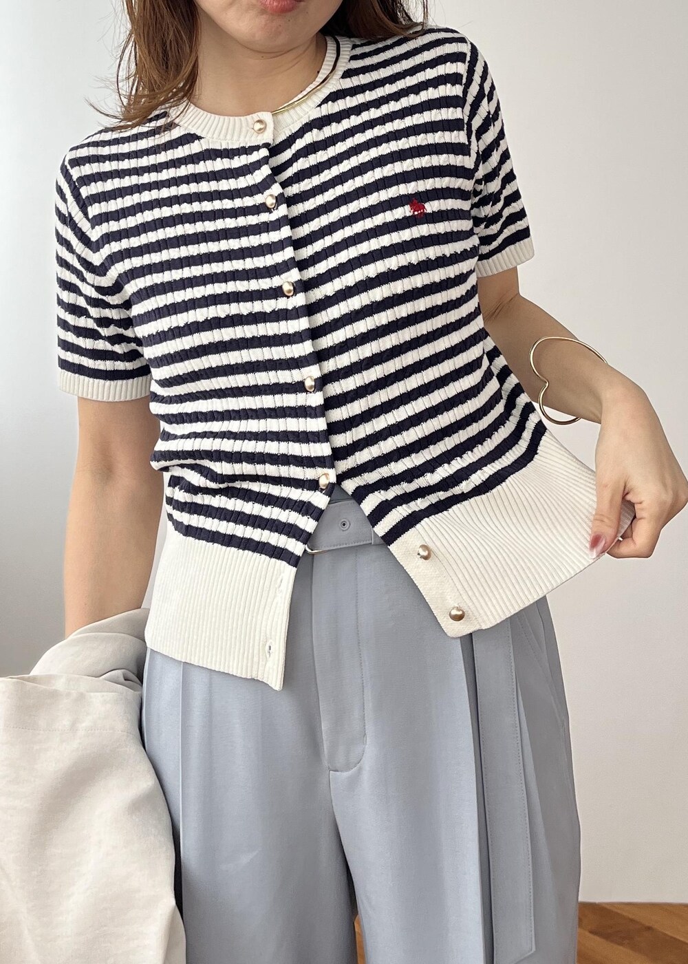 ブラック系のショルダーバッグ、ホワイト系のパンプス、ブルー系のその他パンツを着用したレディースの春コーディネートの10枚目の写真