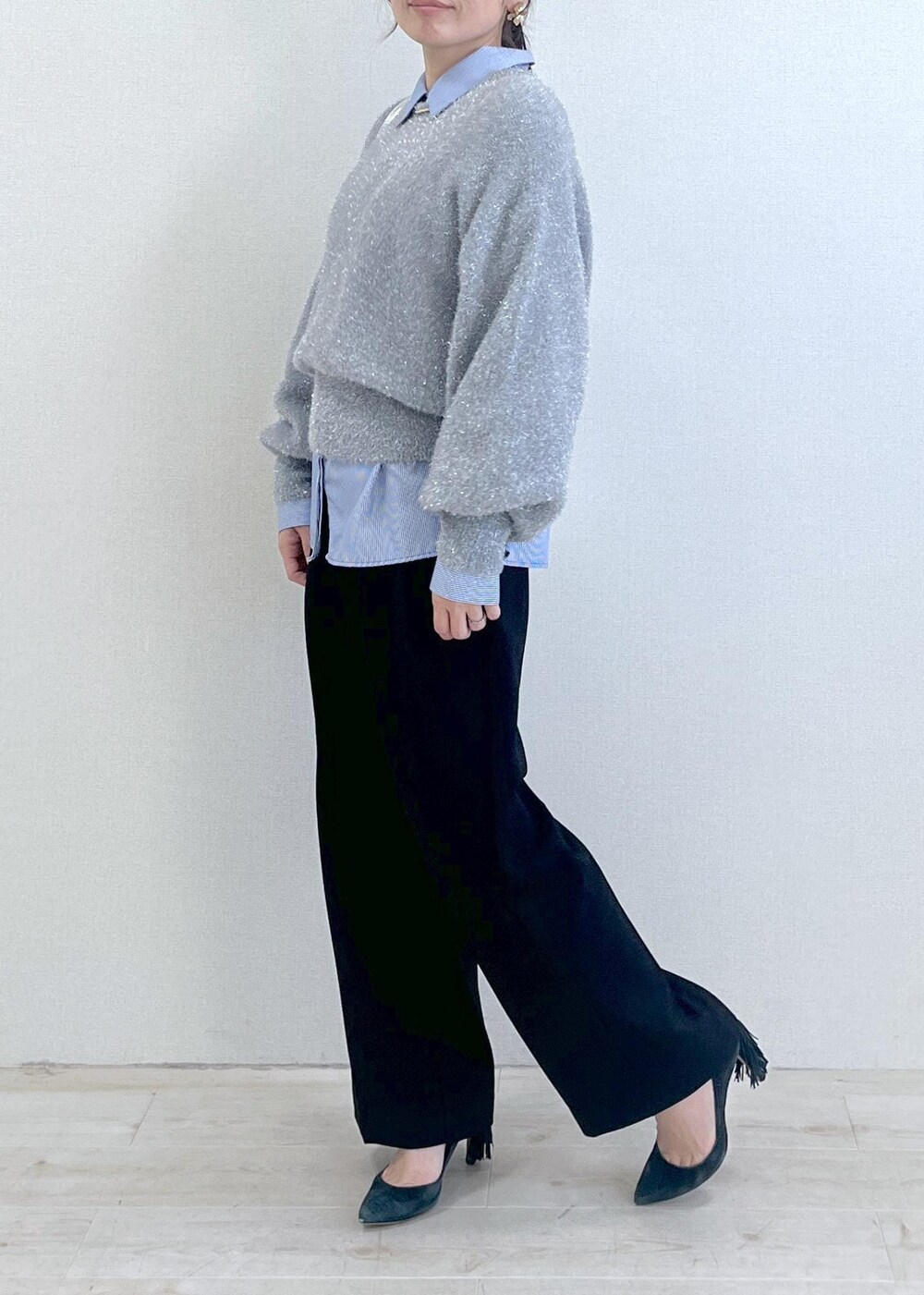 シルバー系のショルダーバッグ、ブラック系のスラックス、ブルー系のシャツ/ブラウスを着用したレディースの冬コーディネートの3枚目の写真